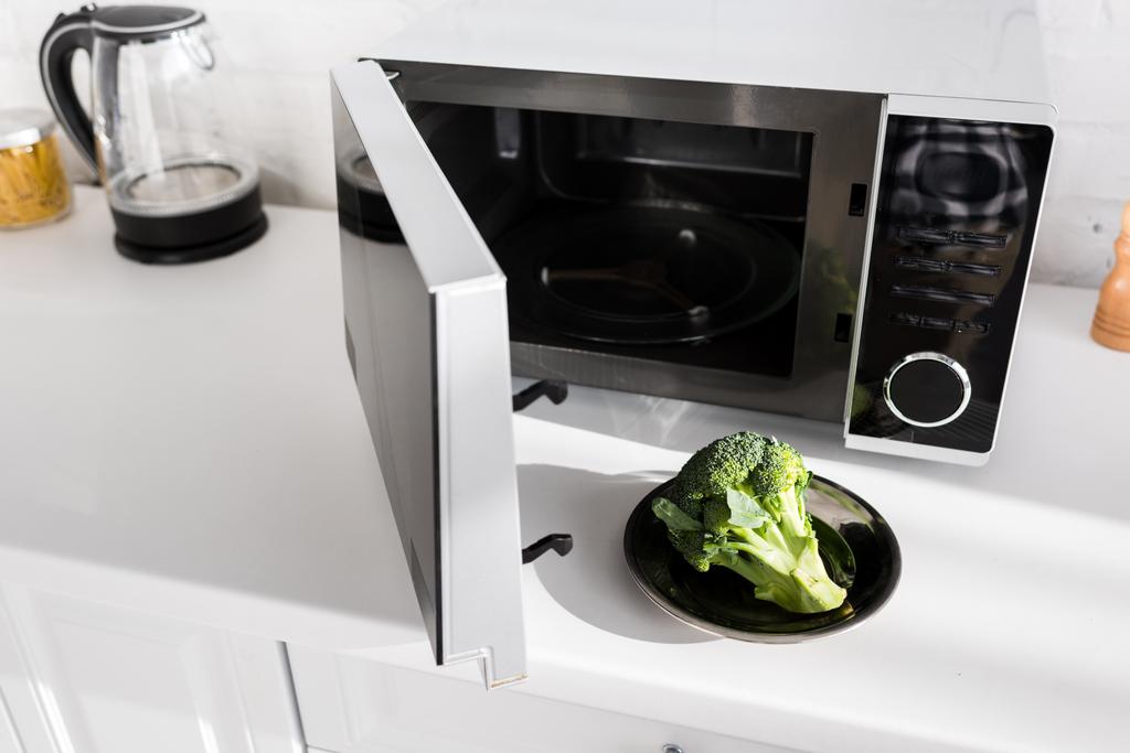 assiette avec brocoli sur assiette près du micro-ondes dans la cuisine
  - Photo, image