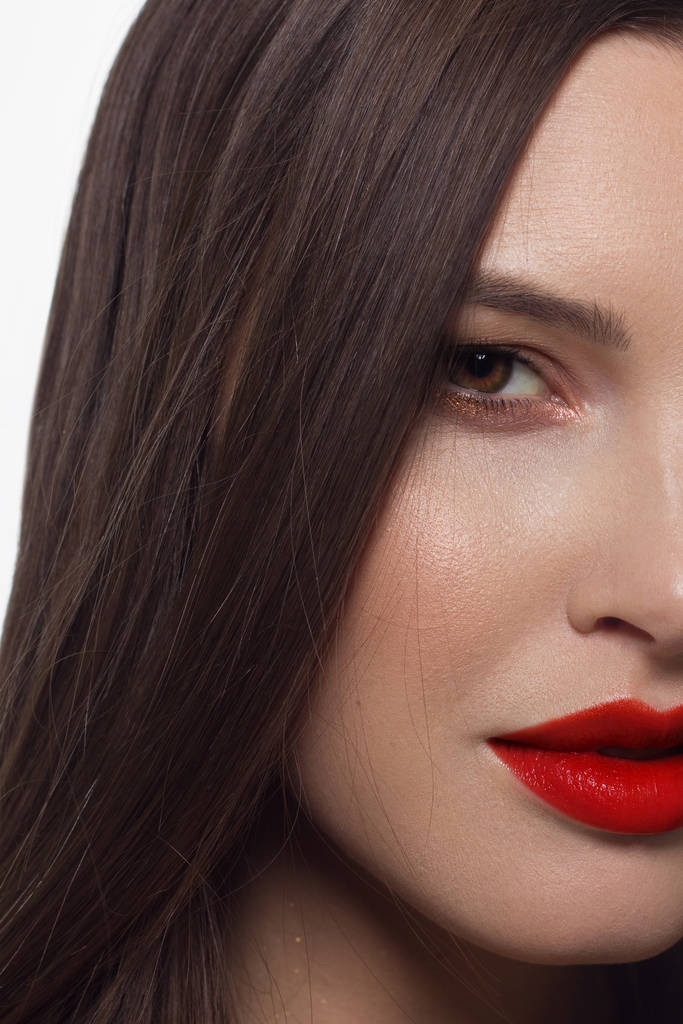 Nahaufnahme Porträt eines sexy europäischen jungen Models mit klassischem Glamour-Make-up und rotem Lippenstift. dunkle Langfrisur, weihnachtliches Make-up, dunkle Lidschatten, blutige lila Lippen mit Glanz - Foto, Bild