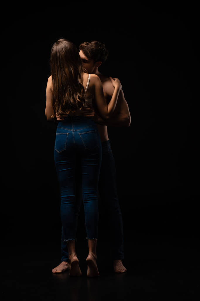 黒の上に隔離されたセクシーな若いカップルのキスのバックビュー - 写真・画像