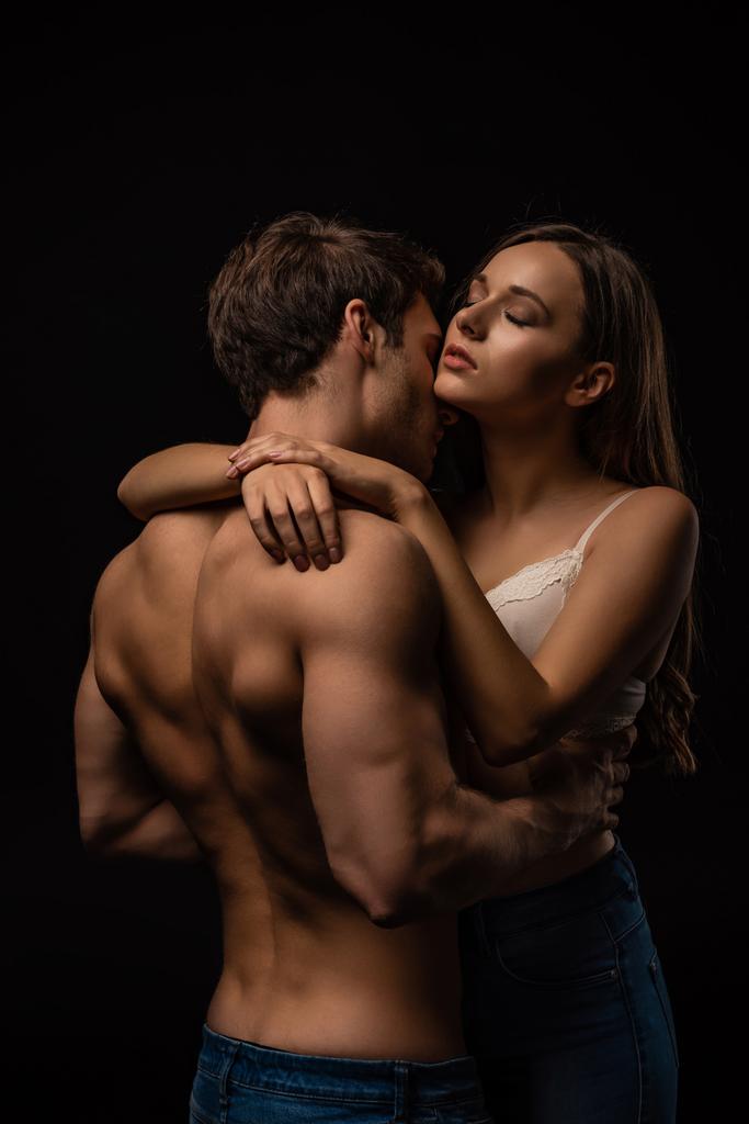 sexy young couple passionately hugging with closed eyes isolated on black - Photo, Image