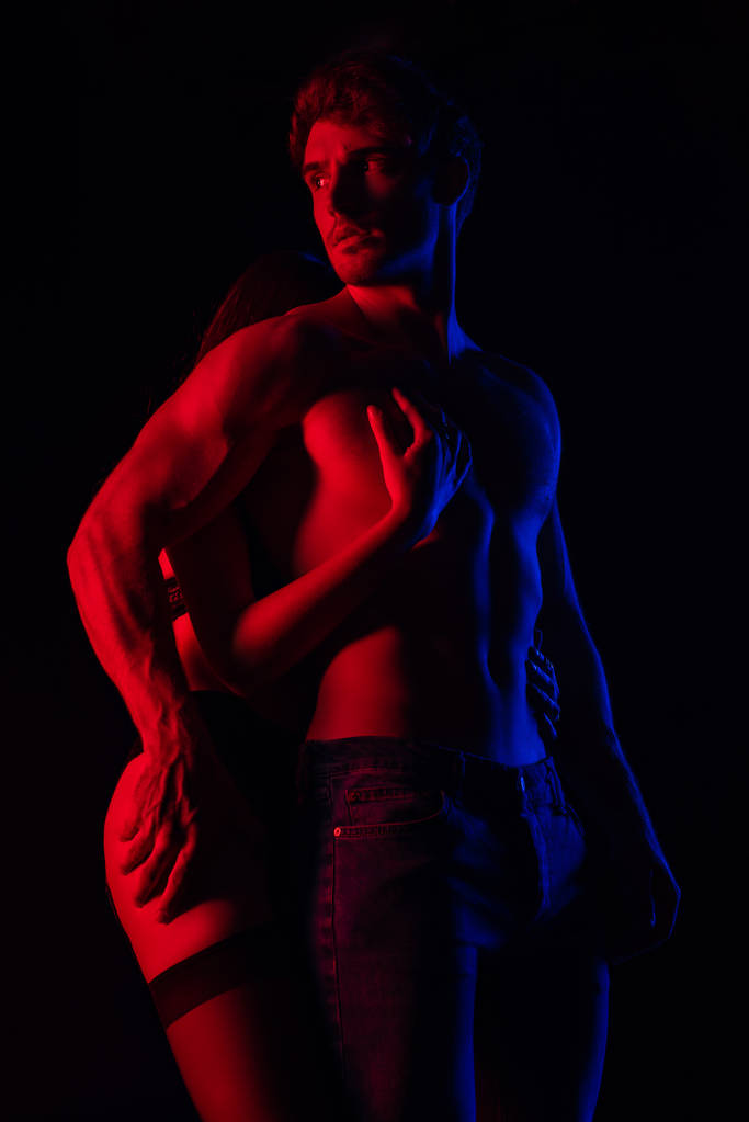 intohimoinen riisuttu seksikäs nuori pari koskettaa toisiaan punaisessa valossa eristetty musta
 - Valokuva, kuva