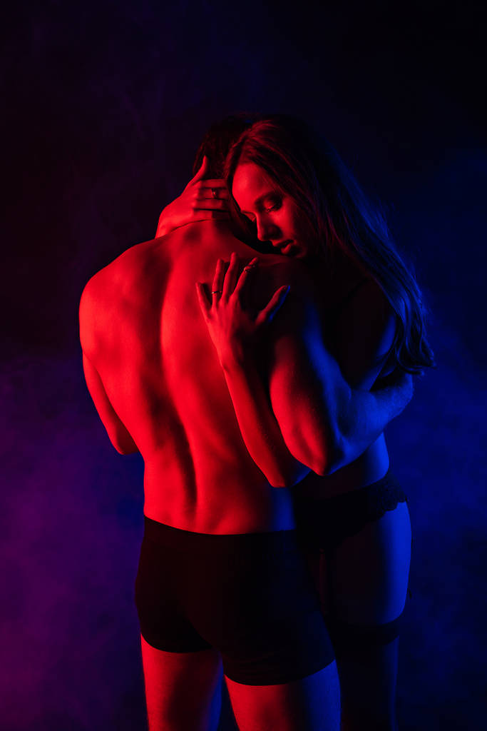 παθιασμένο γυμνό σέξι νεαρό ζευγάρι αγκαλιάζει στο κόκκινο φως - Φωτογραφία, εικόνα