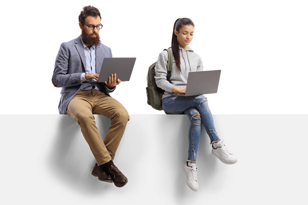 Profesor masculino y una estudiante con computadoras portátiles sentados
  - Foto, Imagen