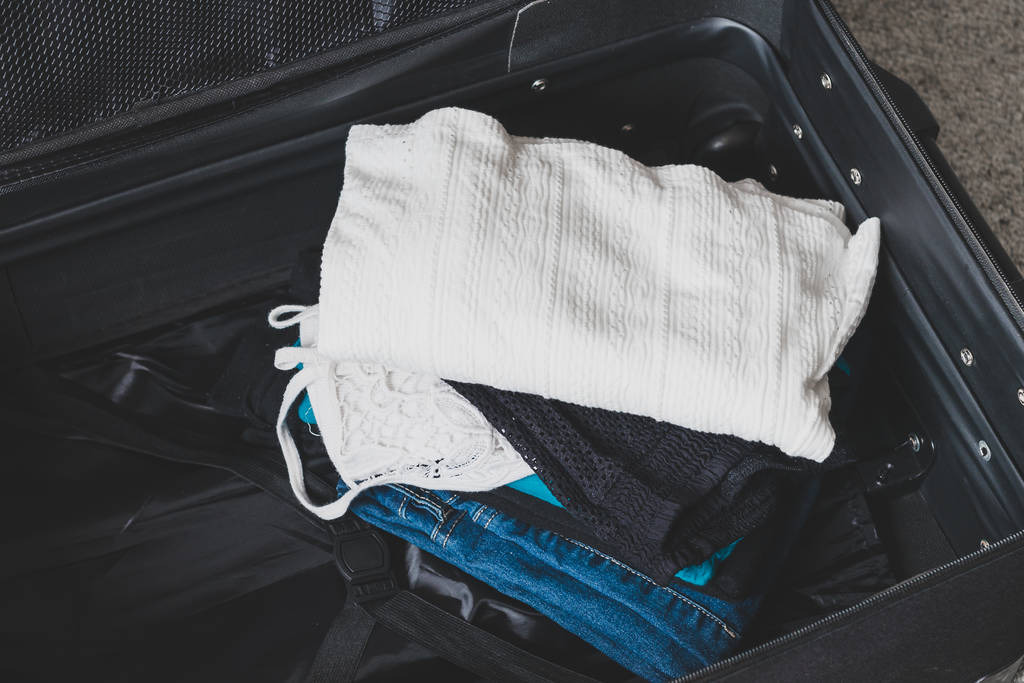 imballaggio per un concetto di vacanza, bagagli con mucchio di vestiti insi
 - Foto, immagini
