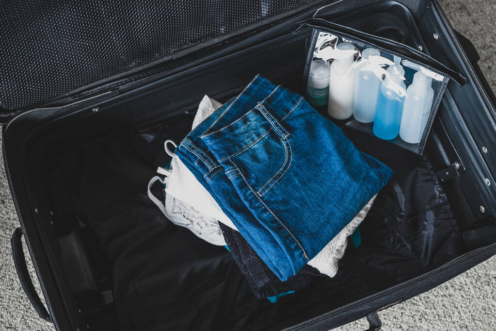 imballaggio leggero per un concetto di vacanza, bagagli con mucchio di vestiti
 - Foto, immagini