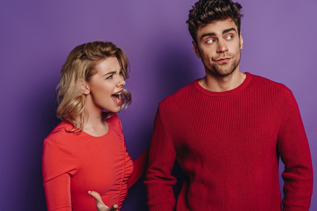 angry girl quarreling with boyfriend looking away on purple background - Photo, Image