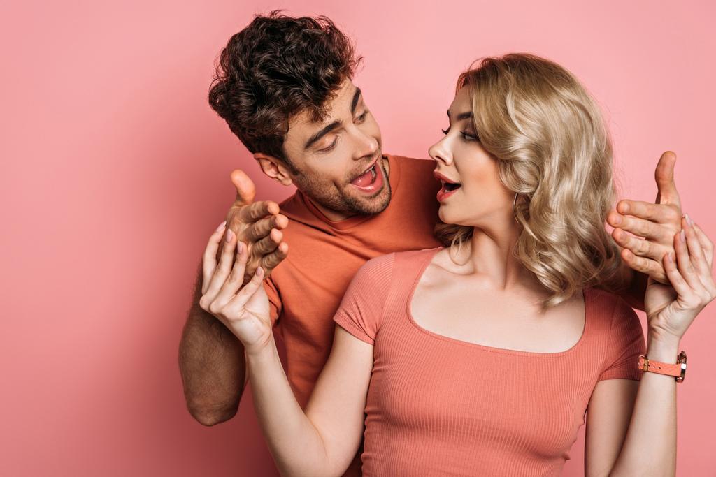 attractive girl stopping boyfriend trying to touch her on pink background - 写真・画像