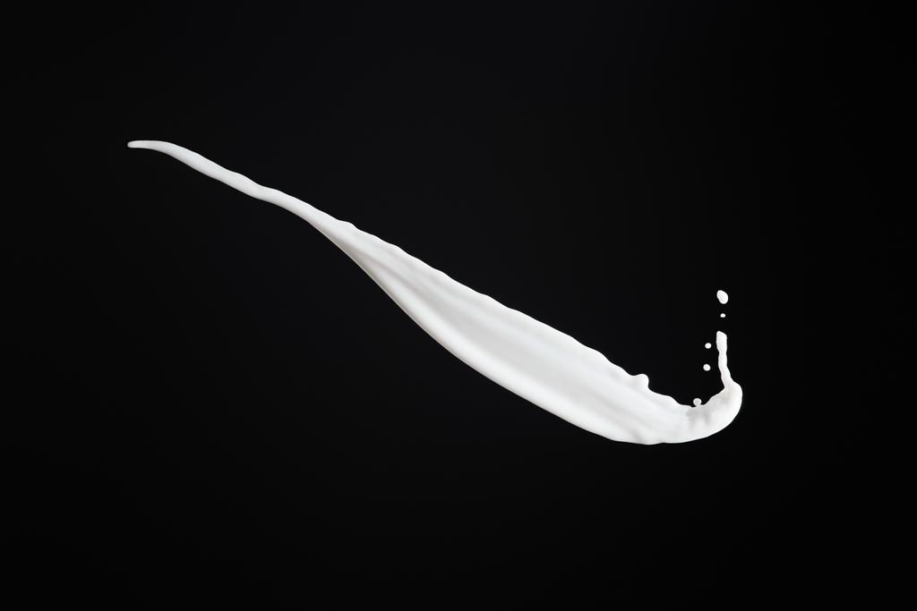 salpicadura de leche blanca fresca con gotas aisladas en negro
 - Foto, imagen
