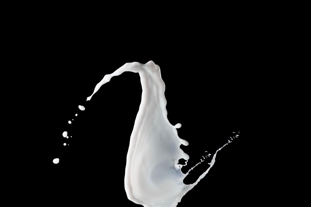 salpicadura de leche blanca fresca con gotas aisladas en negro
 - Foto, Imagen