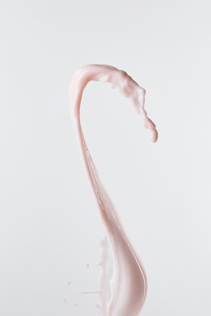 świeże różowe mleko z kroplami wyizolowanymi na białym - Zdjęcie, obraz