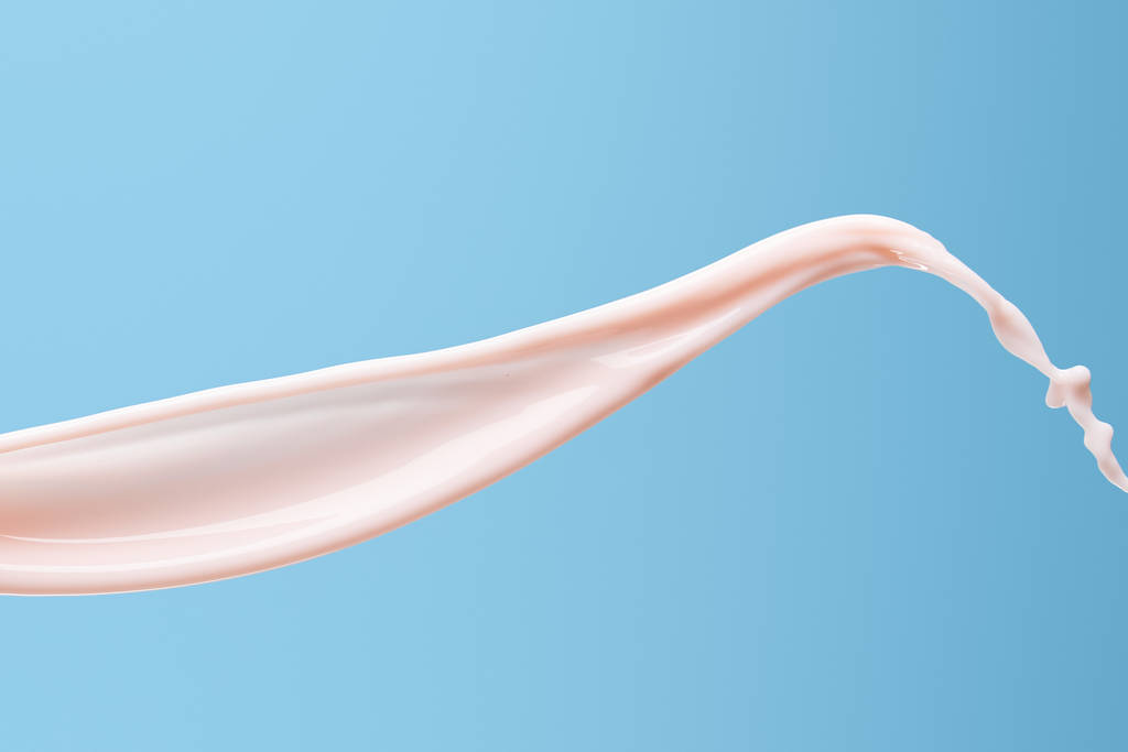 гладкий свіжий рожевий молочний бризки ізольовані на синьому
 - Фото, зображення