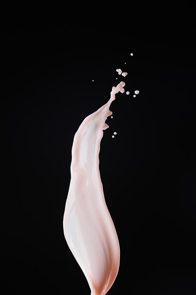 gładkie świeże różowe mleko splash z kroplami izolowane na czarno - Zdjęcie, obraz