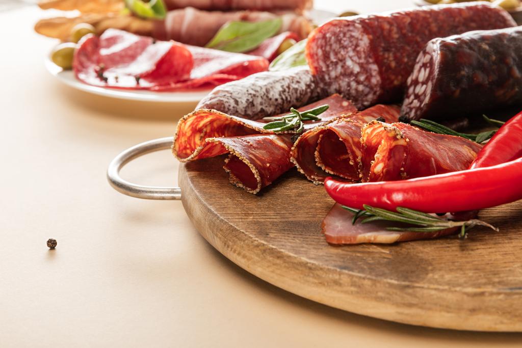 délicieux plats de viande servis avec des olives, des épices et des bâtonnets de pain sur plaque et planche de bois sur fond beige
 - Photo, image