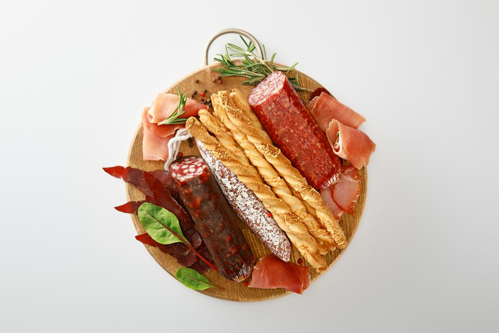 Ekmek ve otlarla servis edilen lezzetli et tabağının üst görüntüsü beyaz üzerinde izole edilmiş. - Fotoğraf, Görsel