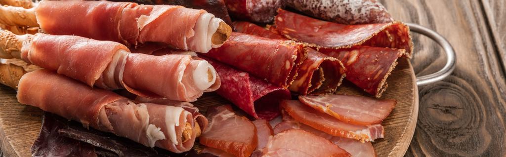 おいしい肉の盛り合わせは木の板の上のパンスティック、パノラマショットで提供 - 写真・画像