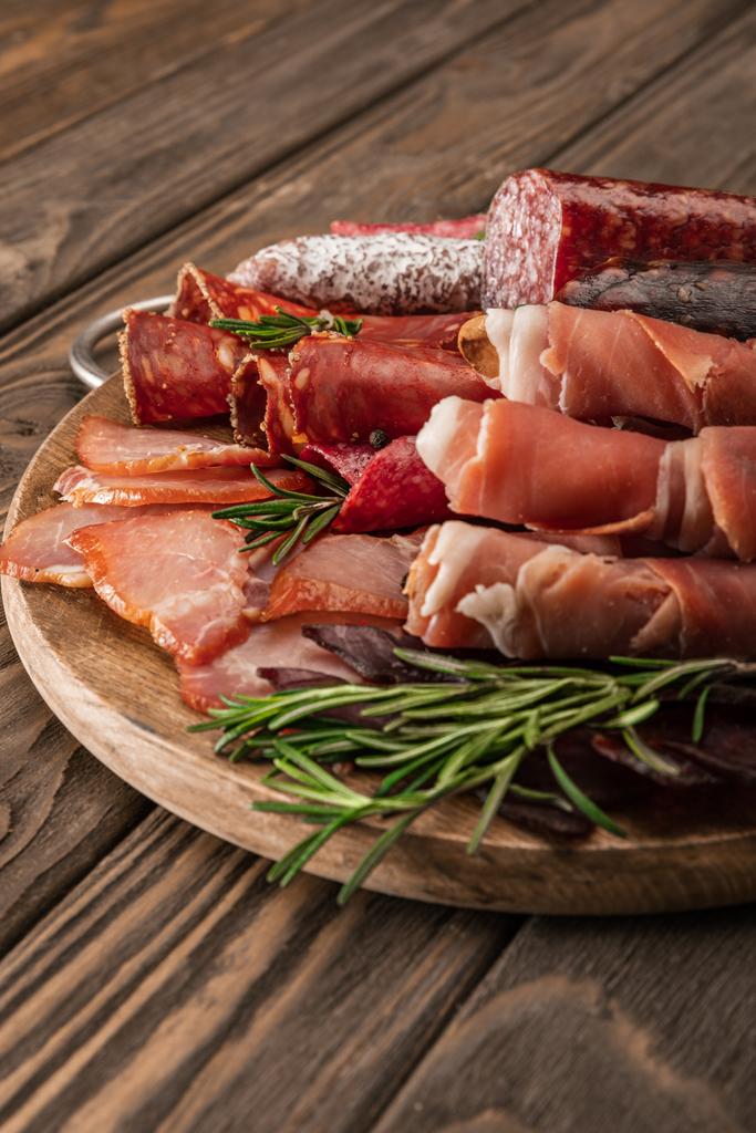 délicieux plateau de viande servi avec du romarin sur une planche de bois
 - Photo, image