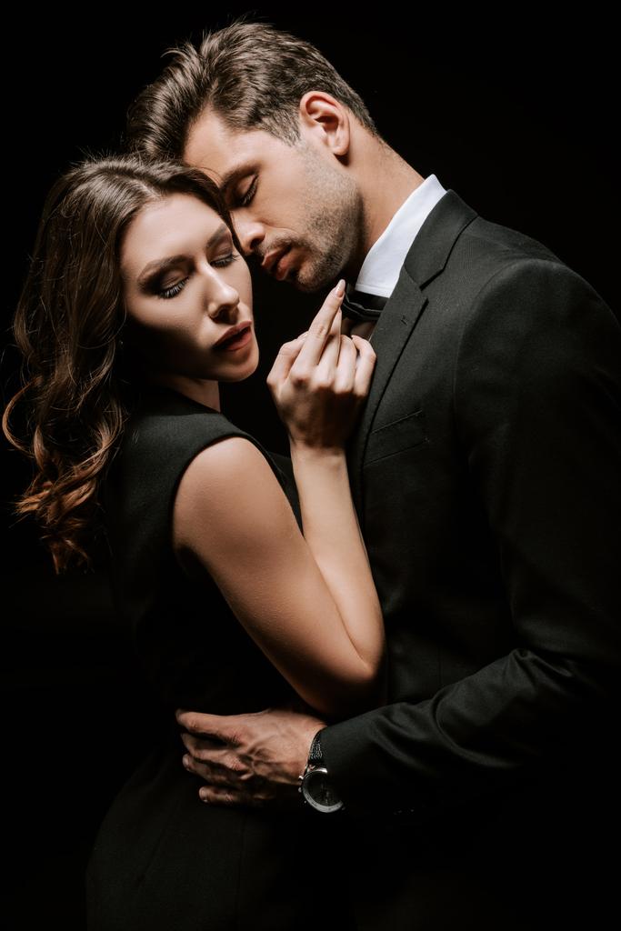 przystojny mężczyzna przytula młody atrakcyjny kobieta odizolowany na czarny  - Zdjęcie, obraz