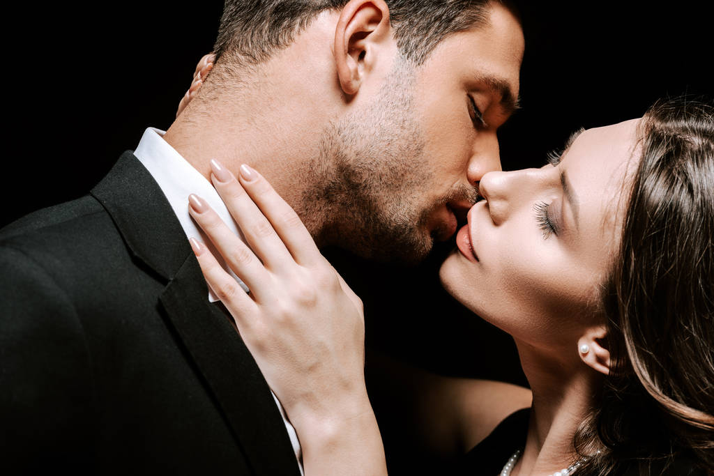 homem beijando com bela mulher isolada no preto
  - Foto, Imagem