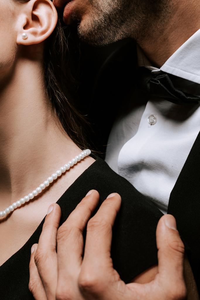 首に真珠のネックレスで女性に触れる男のクロップドビュー  - 写真・画像