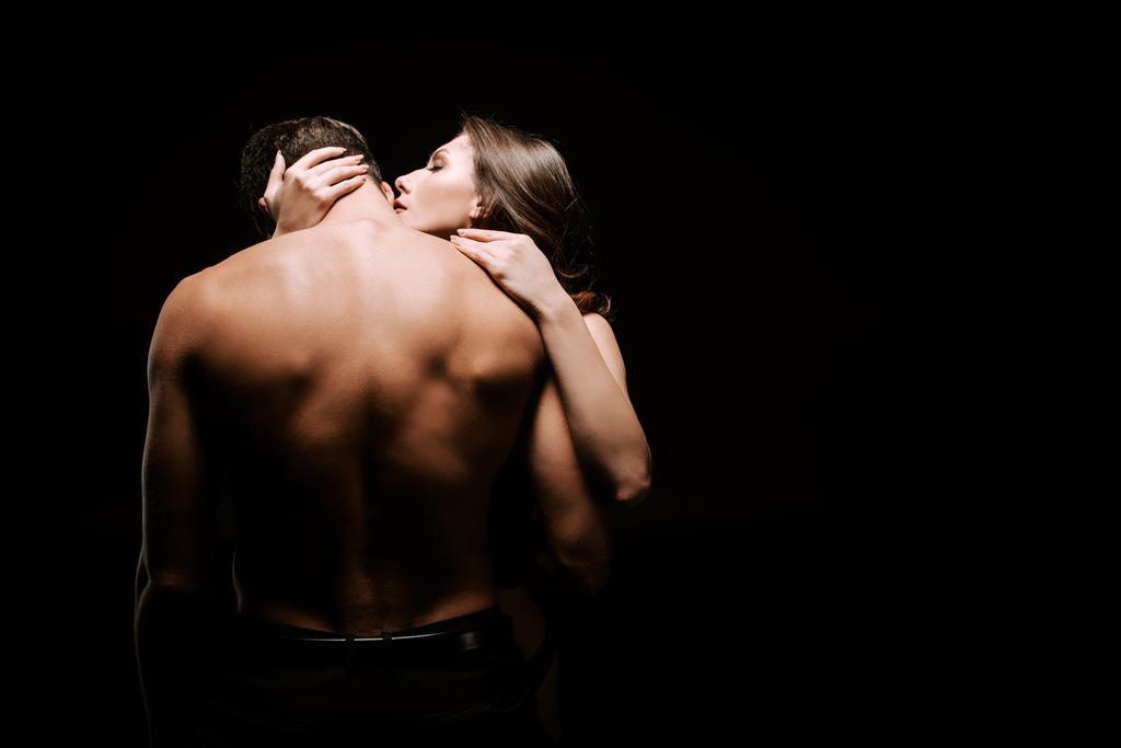 jovem sedutor mulher abraçando muscular namorado isolado no preto
  - Foto, Imagem