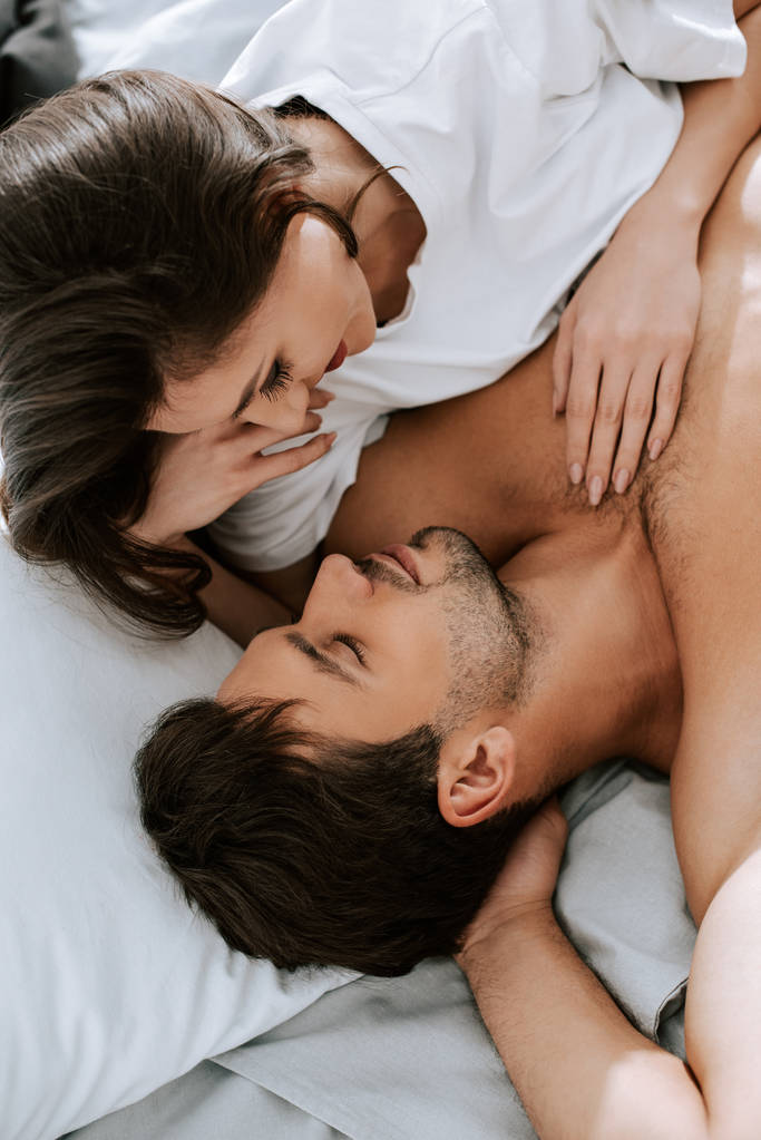 Mutlu bir kadının yatakta yakışıklı bir adamla yatışının en üst görüntüsü.  - Fotoğraf, Görsel