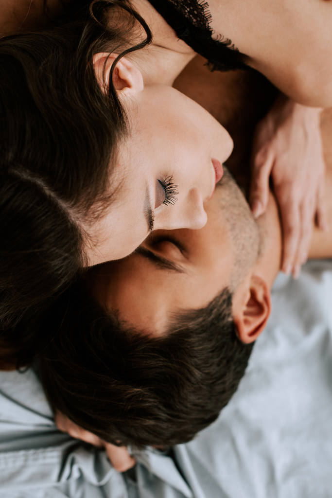vrchní pohled na ženu ležící s mužem na posteli  - Fotografie, Obrázek