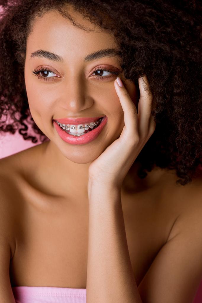 happy attractive african american girl with dental braces, isolated on pink - Photo, Image