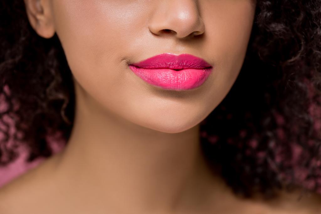 przycięty widok afrykańskiej amerykańskiej dziewczyny z różowymi ustami, odizolowany na różowy - Zdjęcie, obraz
