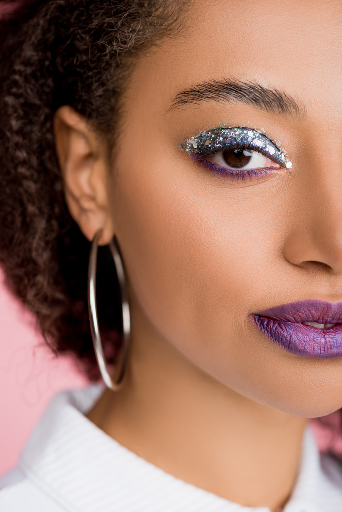 Afrikkalainen amerikkalainen tyttö hopea glitter luomivärejä ja violetti huulet, eristetty vaaleanpunainen
 - Valokuva, kuva