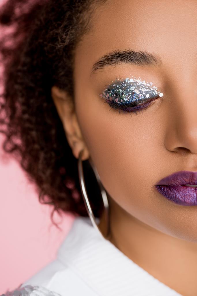 όμορφη Αφροαμερικανή με ασημί γκλίτερ σκιές ματιών και μωβ χείλη, απομονωμένη σε ροζ - Φωτογραφία, εικόνα