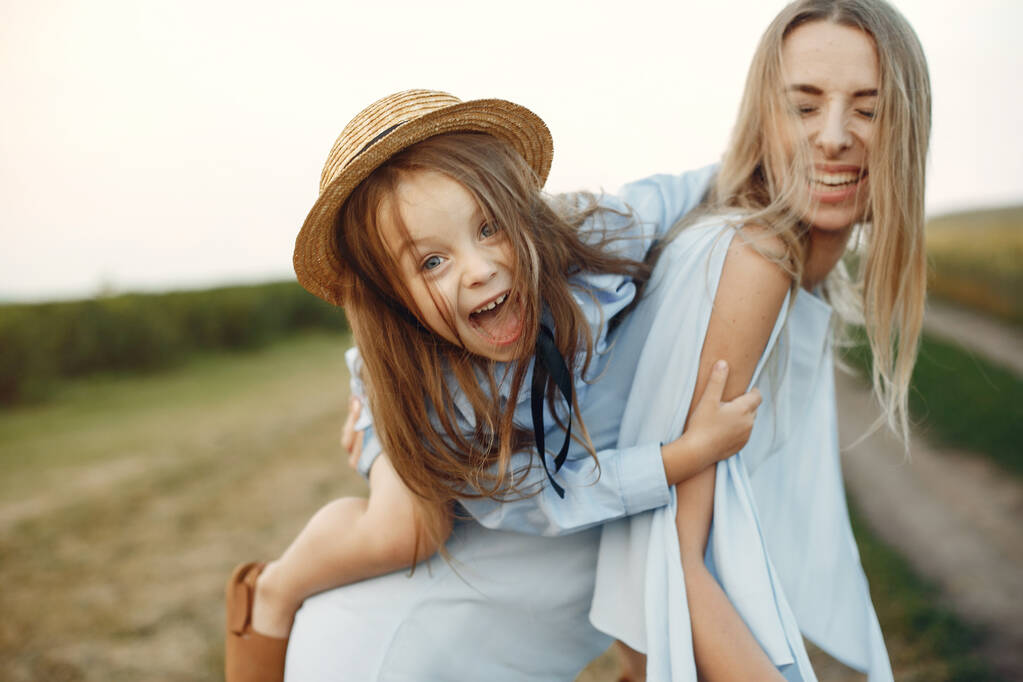 Mutter mit Tochter spielt auf einem Sommerfeld - Foto, Bild
