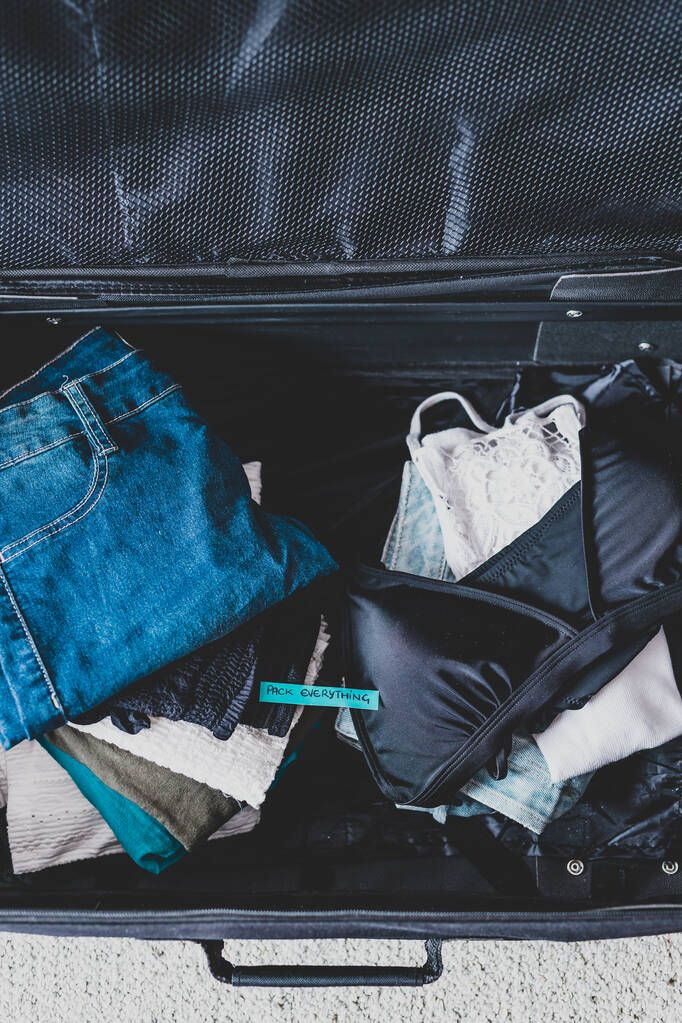 zavazadla s hromadou oblečení a nálepkou Vše na štítku - Fotografie, Obrázek