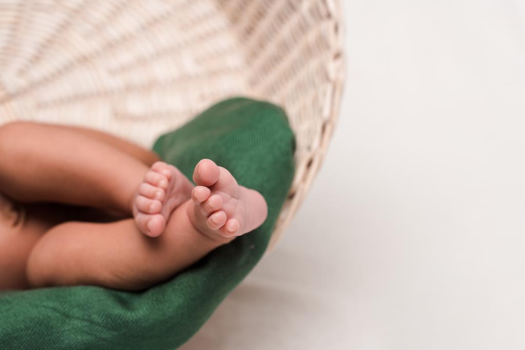 bijgesneden weergave van schattige pasgeboren baby in mand op wit - Foto, afbeelding