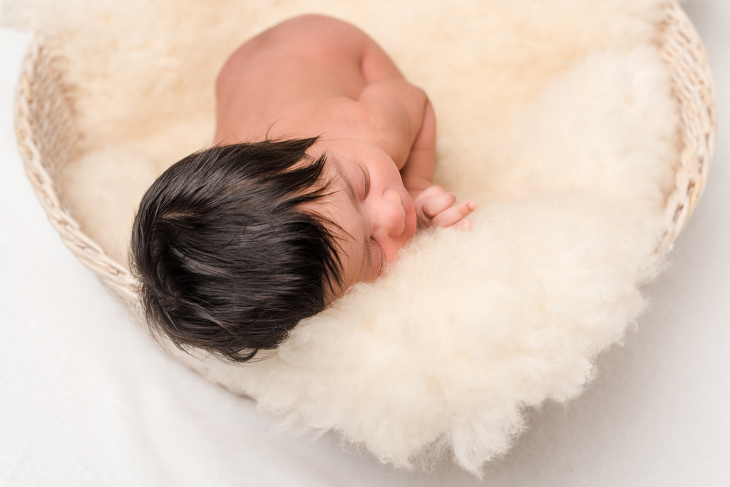 χαριτωμένο νεογέννητο μικτή φυλή μωρό κοιμάται σε απαλή κουβέρτα σε λευκό - Φωτογραφία, εικόνα
