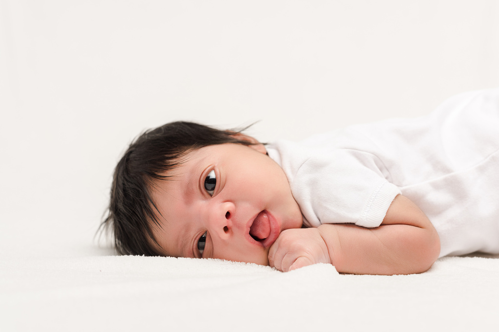 bebé recién nacido bi-racial adorable acostado aislado en blanco
  - Foto, imagen