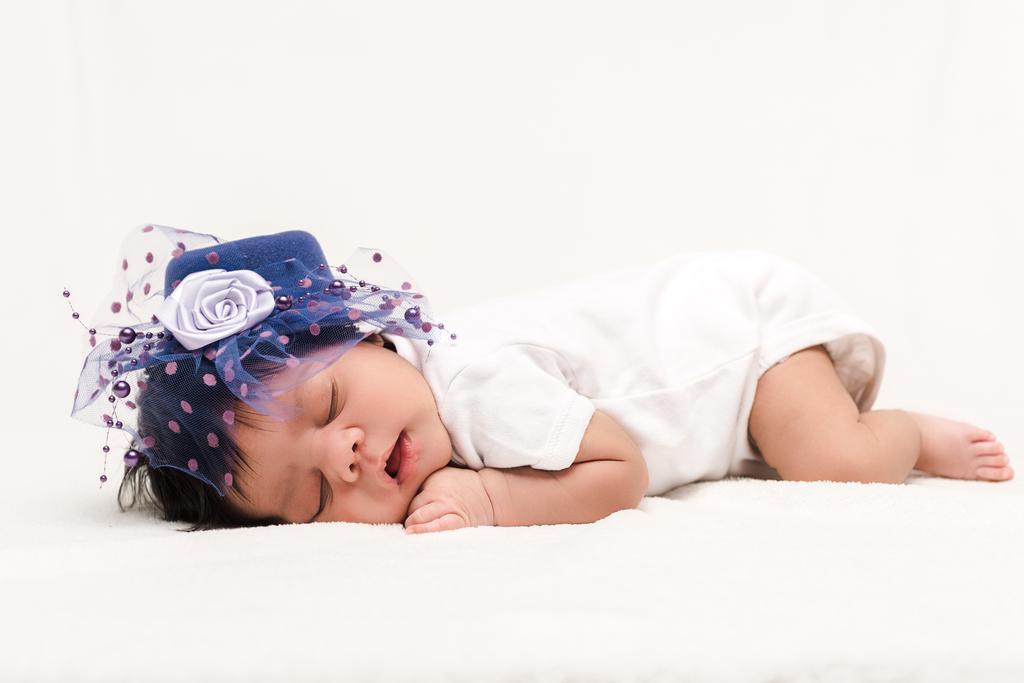 adorable bi-racial recién nacido bebé en azul sombrero durmiendo en blanco
  - Foto, imagen