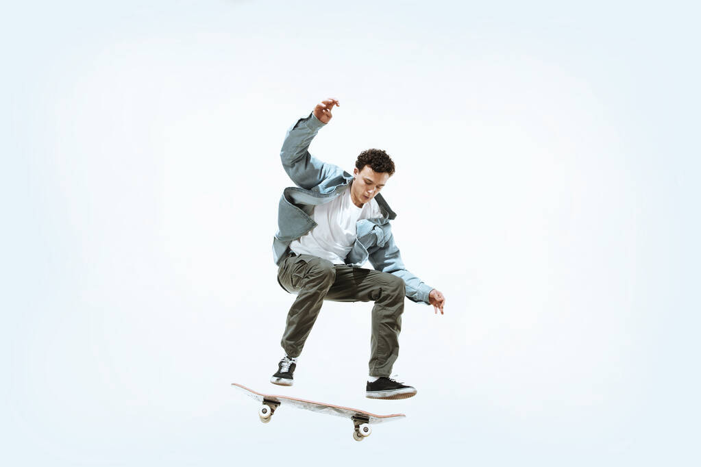 Kavkazský mladý skateboardista na koni izolované na bílém pozadí - Fotografie, Obrázek