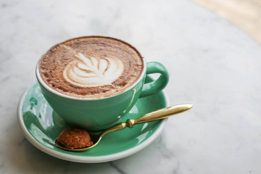 Una taza de café con arte latte en la parte superior
 - Foto, imagen