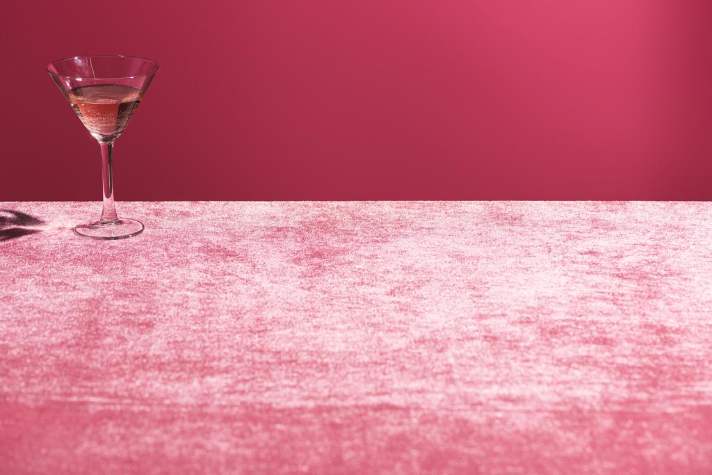 bebida de alcohol en vidrio sobre tela de terciopelo rosa aislado en rosa, concepto femenino
 - Foto, imagen