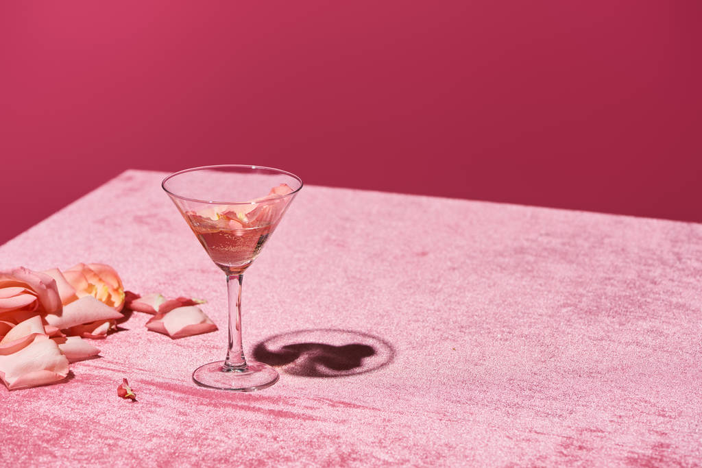 rózsa szirmok üveg közelében velúr rózsaszín ruha elszigetelt rózsaszín, lányos koncepció - Fotó, kép