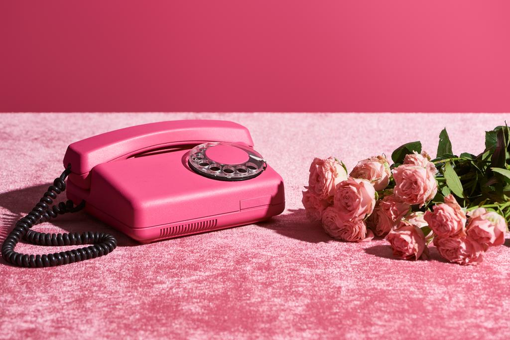 τριαντάφυλλα και vintage τηλέφωνο σε βελούδινο ροζ πανί που απομονώνονται σε ροζ, κοριτσίστικη έννοια - Φωτογραφία, εικόνα