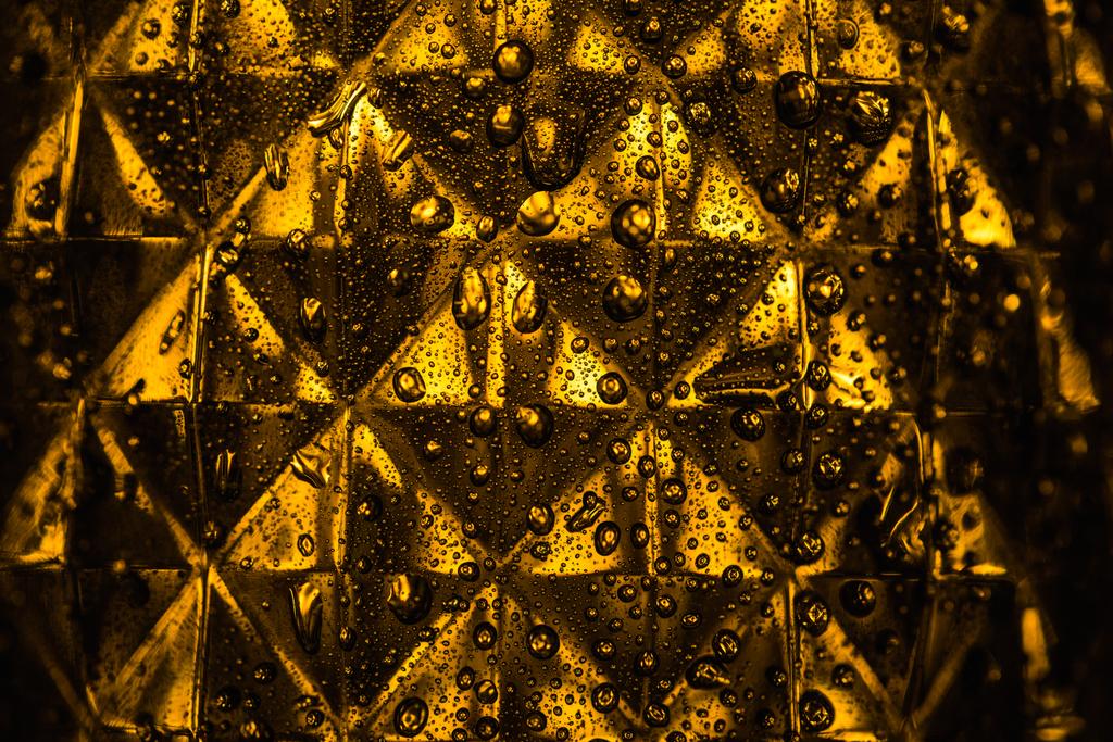primer plano vista de vidrio geométrico facetado con iluminación amarilla en la oscuridad
 - Foto, Imagen