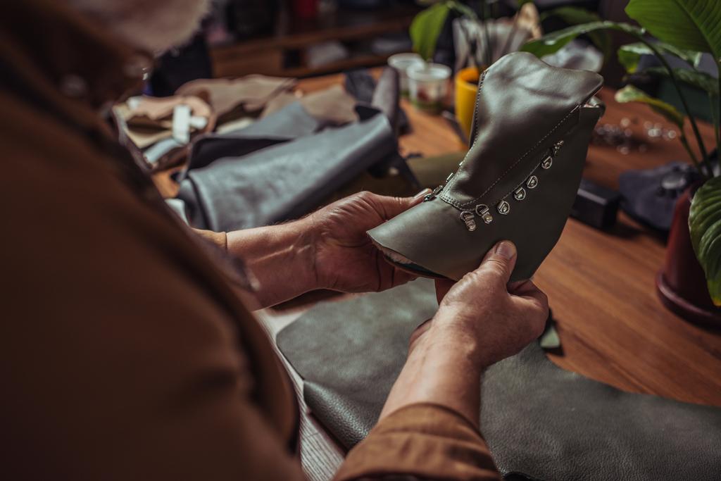 Shoemaker 'ın atölyede bitirilmemiş ayakkabının deri detaylarını tuttuğu kırpılmış görüntüsü - Fotoğraf, Görsel