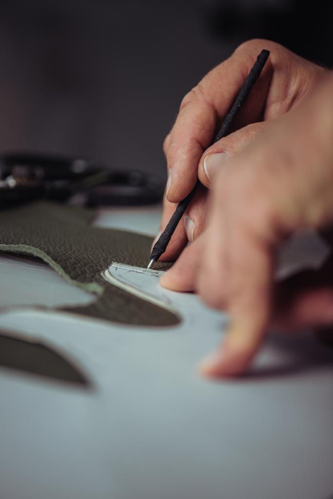 visão parcial do sapateiro marcação de couro com caneta especial perto do modelo
 - Foto, Imagem
