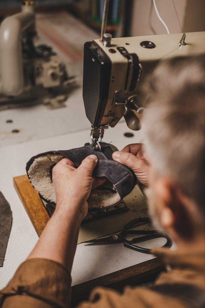 ミシンに対するスエードシューズのコブラー縫製部分の選択的焦点 - 写真・画像
