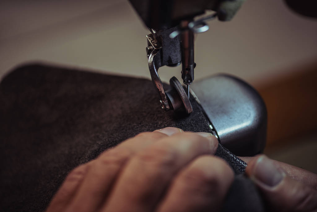 partial view of shoemaker sewing genuine leather on sewing machine - Photo, Image