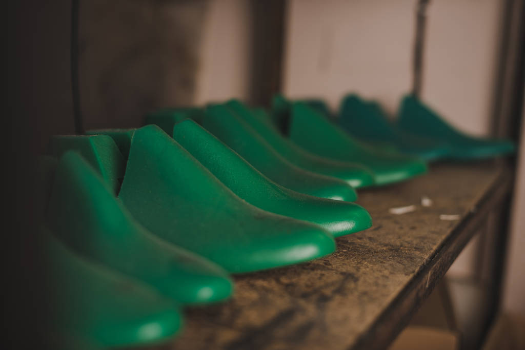 селективная направленность различных ботинок на стойку в мастерской
 - Фото, изображение