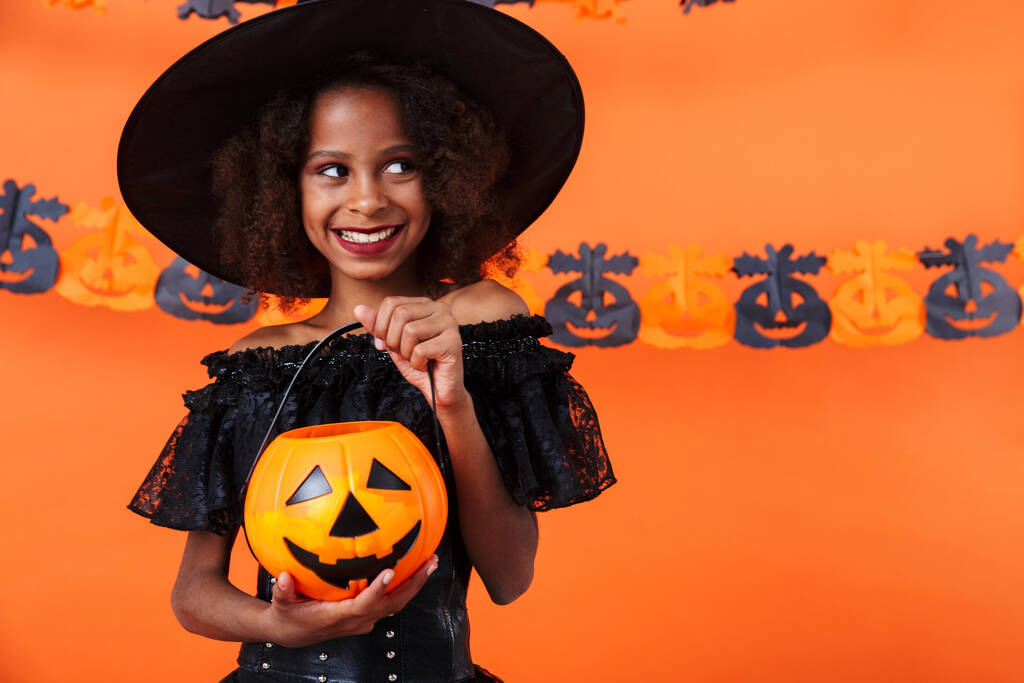 Image of joyful african american girl smiling and holding toy pumpkin - Fotoğraf, Görsel