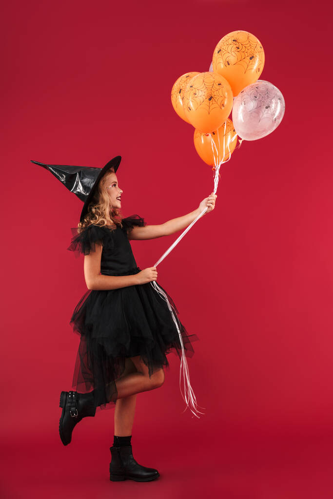 Feliz niña bonita bruja en el disfraz de Halloween carnaval
 - Foto, Imagen