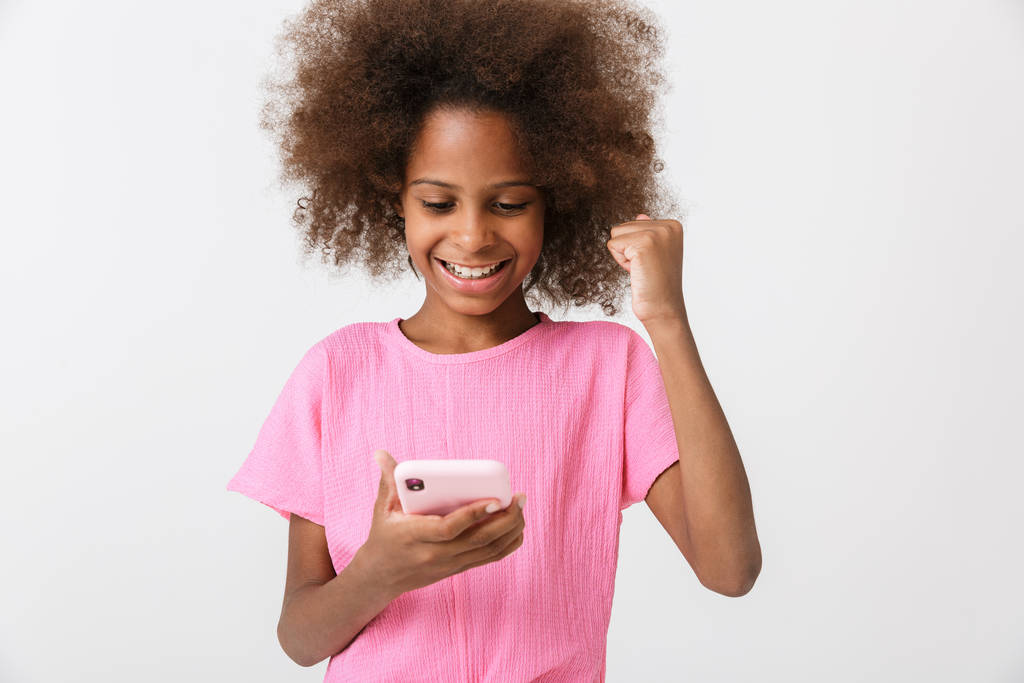 Feliz niña africana joven usando el teléfono móvil
. - Foto, Imagen